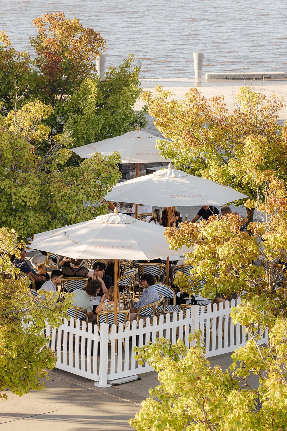 Guests enjoying Margot's tree-lined terrace beside Lake Burley Griffin
